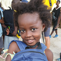 Haitian child wearing backpack as part of the Haiti Humanitarian outreach program